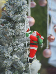 Santa Claus toy close-up on the background of a blurred Christmas tree
