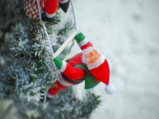 Santa Claus toy close-up on the background of a blurred Christmas tree