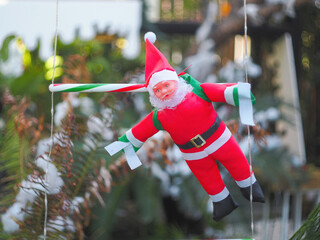Santa Claus toy close-up on the background of a blurred Christmas tree