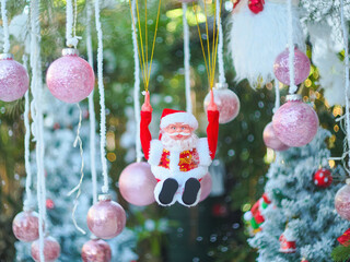 Santa Claus toy close-up on the background of a blurred Christmas tree