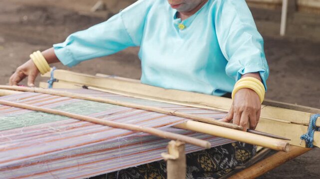 closeup, indonesian woman hand weaving on flores island, indonesia, tradition and culture, slow motion
