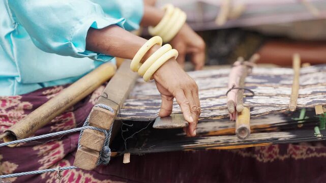 closeup of woman hand weaving fabric on flores island indonesia, traditional indonesian culture, tradition, slow motion