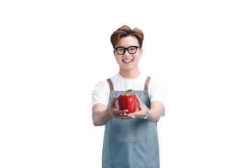 Fresh Harvest Offer: A cheerful individual, adorned in an apron, extends a vibrant red bell pepper toward the viewer, embodying freshness and the bounty of the harvest.