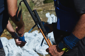 Outdoor Hiking Team Preparing Gear With Trekking Poles And Backpacks