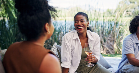 Fototapeta premium People, wine and laugh with picnic for social gathering, funny gossip and bonding outdoor. Friends, smile and communication with alcohol in nature for conversation, summer vacation and connection