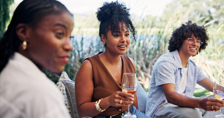 Friends, wine and smile with picnic for bonding, social gathering and reunion outdoor. People, laugh and communication with alcohol in nature for funny conversation, summer vacation and connection