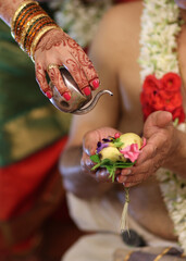 Tamil brahmin wedding -close up of hands performing pooja in indian tradition