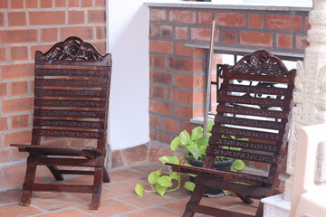 a balcony with 2 wooden antique chairs