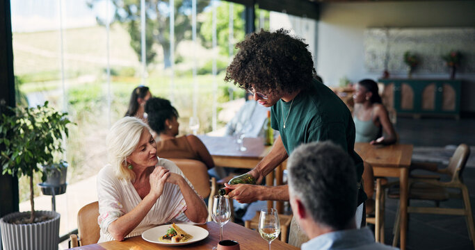 Restaurant, waiter or serving wine to couple, romantic date or fine dining experience for anniversary. Fancy cuisine, marriage celebration or server with gourmet drink, hospitality or mature people