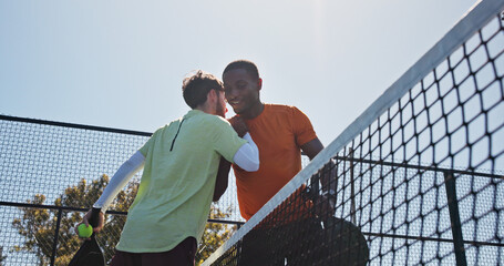 Fitness, hug and padel with men on court together for practice or training session. Exercise, handshake or tennis with coach and player talking outdoor for skill or sports development from below © peopleimages.com