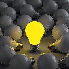 Single glowing yellow lightbulb amidst many gray bulbs