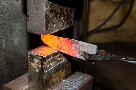 A Blacksmith making knives in the old traditional smithy factory - Powered by Adobe