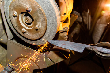 Blacksmith, knife sharpening, sparks, metal. Forging molten metal. Making knives.forge workshop