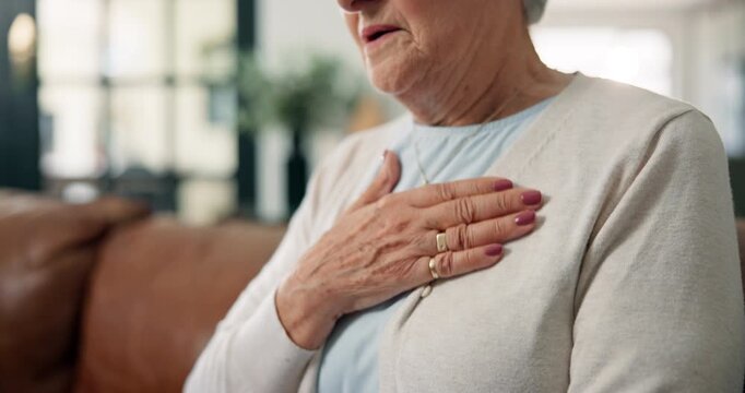 Heart attack, hands of old woman and chest pain on sofa with health fail, hypertension and panic. Anxiety, elderly person and cardiac arrest symptoms in home with artery pressure or medical emergency
