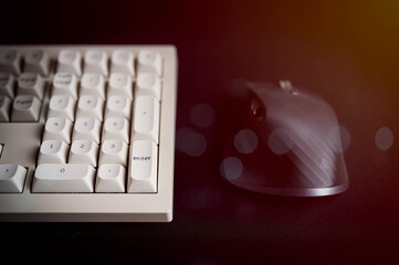 Close-up of a minimalist keyboard and ergonomic mouse on a dark surface, representing modern workspace setup, technology tools, digital productivity, and clean professional design.