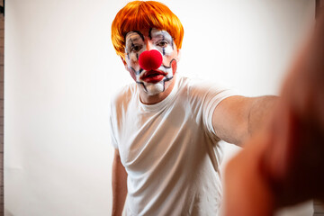 Clown in makeup and wig holding camera for a selfie