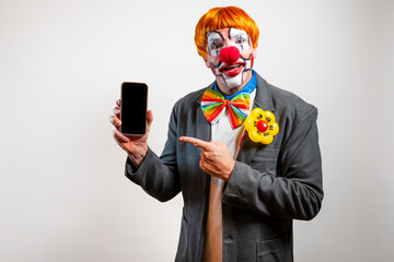 Clown pointing finger at blank screen of a mobile phone