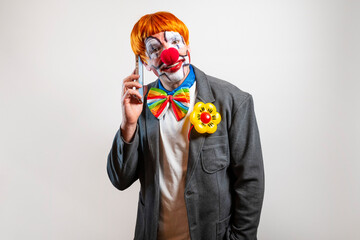 Clown man talking on smartphone communicating with funny expression