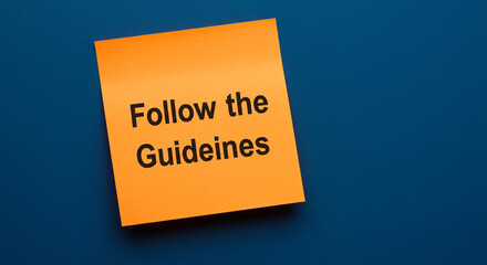 Orange sticky note with Follow the Guidelines text on blue background