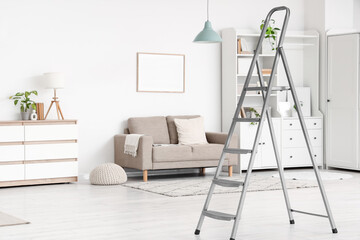 Interior of living room with stepladder, sofa and shelf unit