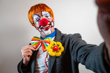 Clown smiling taking selfie against white background
