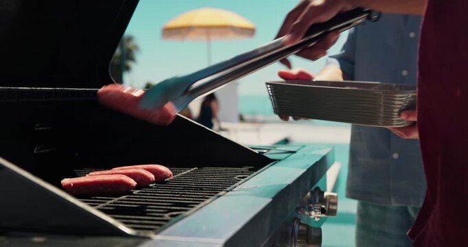 Barbecue, hotdog and grill with hands of person outdoor for cooking, celebration and lunch. Nutrition, bbq hangout and health with people and cookout event on patio of home for food and meat