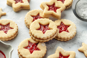 Christmas raspberry linzer cookies on white marble background close up. Festive dessert, winter treat