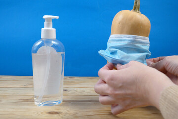 pumpkin wearing a face mask for protection from coronavirus with halloween face. Halloween and virus