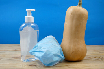 pumpkin wearing a face mask for protection from coronavirus with halloween face. Halloween and virus