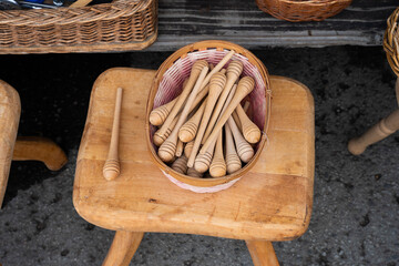 A bowl filled with traditional wooden honey dippers, used for extracting honey from jars. 