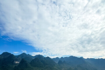 Dramatic Karst Mountains Under A Vast Expanse Of White Clouds And Bright Blue Sky, Natural Landscape Photography, Scenic Vista