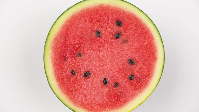 Macro texture of rotating fresh watermelon flesh. Red fruit pulp background with seeds.