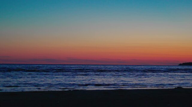 Scenic view of calm ocean waves at sunset with a colorful gradient sky. Peaceful twilight atmosphere, ideal for themes of relaxation, travel, nature, and meditatio