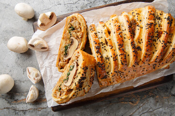 Vegan wellington with mushrooms, spinach and spices close-up on a wooden board on the table. Horizontal top view from above