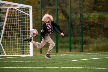 boy plays street football at an outdoor stadium.