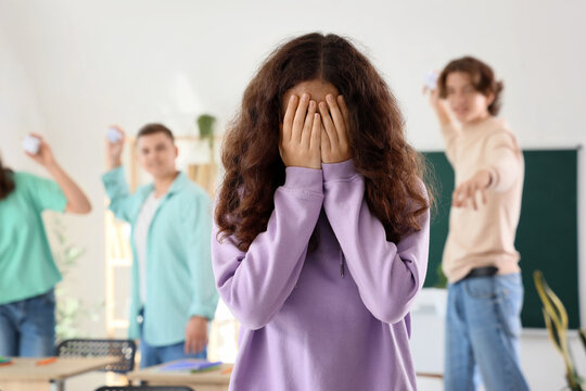 Bullied teenage girl crying in classroom