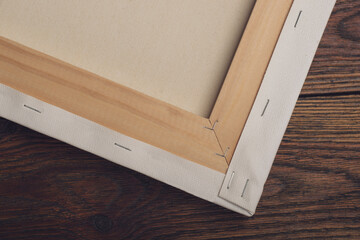 Stretched canvas on wooden stretcher frame lying on textured table