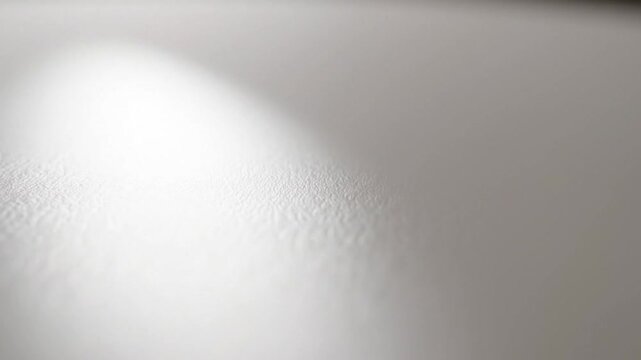 Close-up of a gray surface with a bright light reflection on the left side.