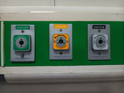 Jakarta, Indonesia - December 16, 2025:  Close up of medical gas outlets for a hospital's piped gas system mounted on a bed head unit or wall panel. For patient care.