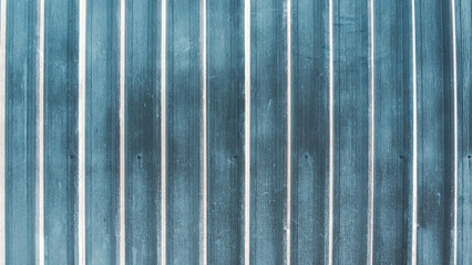 Blue corrugated metal sheet wall texture, Vertical zinc fence panel background with weathered surface.