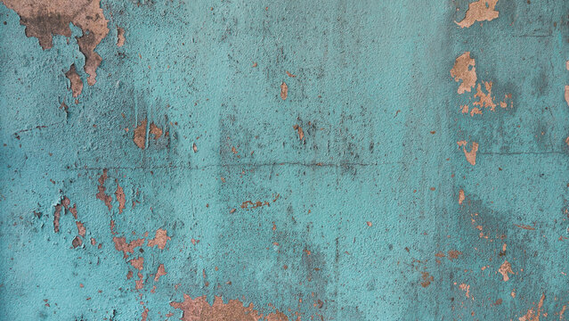 Peeling teal paint on old concrete wall, grunge blue texture background with cracked surface