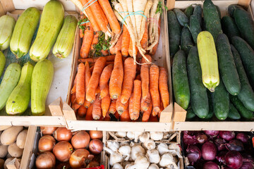 Cauliflower, zucchini, carrots, and other vegetables on a market stall.

