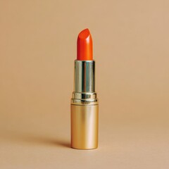 A single tube of vibrant orange lipstick with a golden metallic casing against a smooth, neutral beige background.
