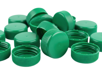 Bright emerald green plastic screw bottle caps scattered on a transparent background, macro detail highlighting ribbed edges and glossy industrial texture, shallow dof. Concept of plastic
