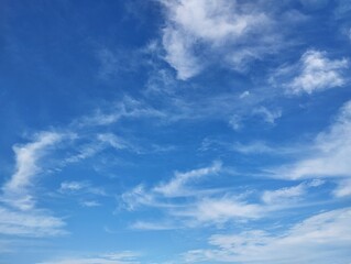 Fototapeta premium Clear blue sky with a few clouds. The sky is very bright and the clouds are scattered throughout in summer season