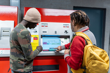 Men buying subway tickets from vending machine for urban public transport