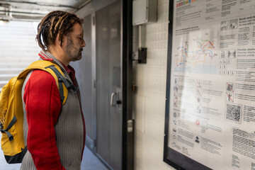 Man planning subway journey, reading map, navigating urban public transport system