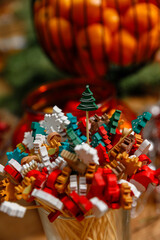 Close-up of colorful Christmas wooden toothpicks and appetizer skewers shaped like Christmas trees and reindeer in a glass. 