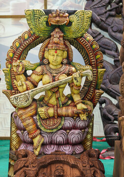 A Divine sculpture of Goddess Saraswathi carved from sacred wood, idol, statue, Hinduism, intricate, spirituality, wealth, Saraswathi puja,   worship, India.
