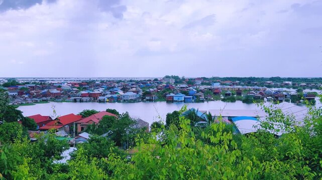 Viewpoint of a flooded fishing village near the Krahom Temple, Cambodia. From the mountain Krahom (Pnom Krom) overlooking the lake Tonlesap. Houses are built on high stilts. Rainy season. 4К